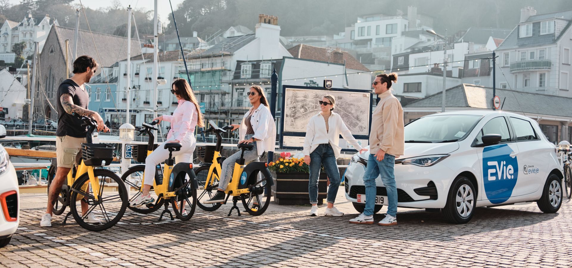 A group of friends on EVieBikes meeting a friend in an EVie Renault Zoe.