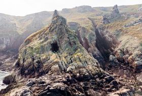 Cliffs along a rocky coast with a cave.