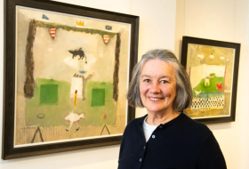 Artist stood in front of her work in a gallery situation
