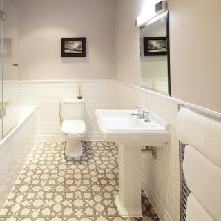 An ensuite bathroom with modern tiling, bath, shower, basin, and toilet