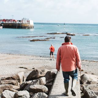 Man walking his dog on the beach at Rozel Bay