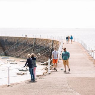 A group or friends and family on the pier at La Rocquw Harbour