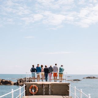 A group or friends and family on the pier at La Rocquw Harbour