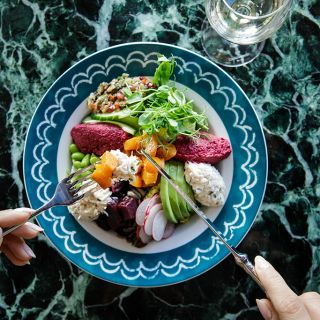 Vibrant Buddha Bowl salad dish with avocado, hummus, radish and other vegetables