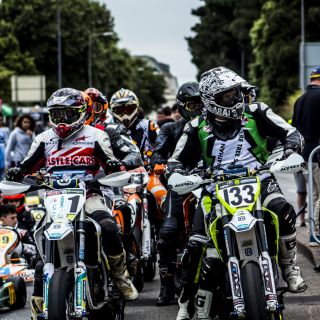 A group of modern supermoto riders preparing in the paddock