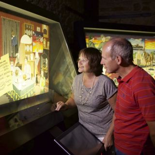 Couple look at the Occupation Tapestry panel in the gallery