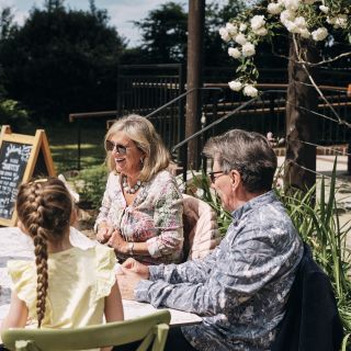 La Hougue Bie Family sit outside having coffee