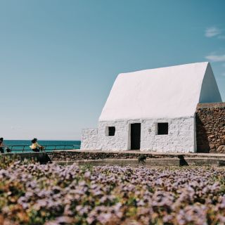 Cyclists going past the White Hut in St. Ouen