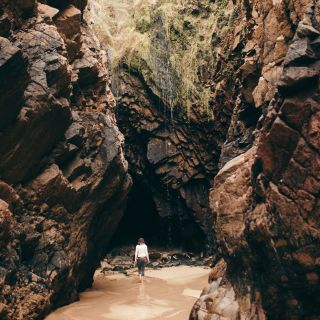 Lady walking into the caves at Plu00e9mont Bay