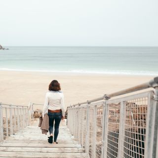 Person strolls down the walkway to Plu00e9mont Beach