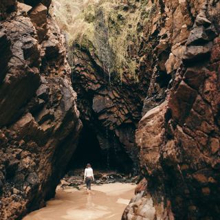 Lady walking into the caves at Plu00e9mont Bay