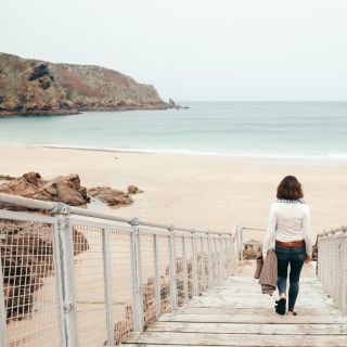 Person strolls down the walkway to Plu00e9mont Beach