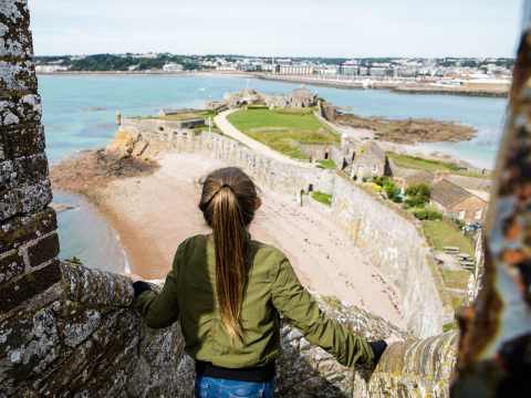 Girl looks at view from the top of the castle