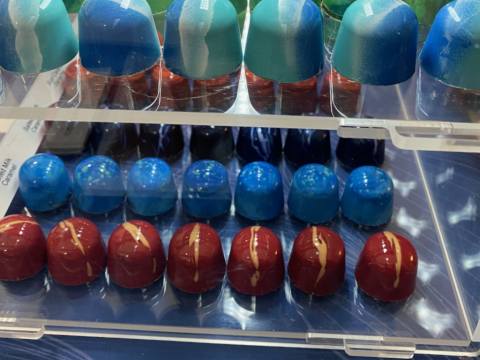 Chocadyllic chocolate display cabinet with multiple colourful and shiny chocolates in rows