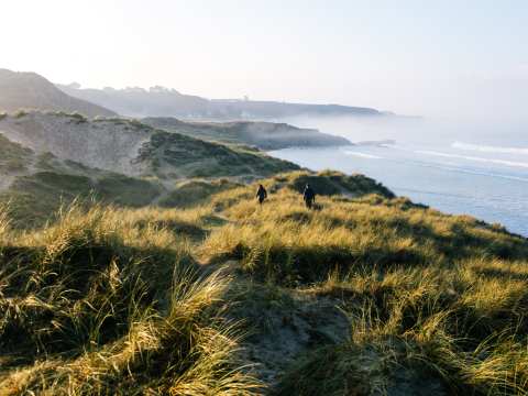 People walking in the sand dunes at St. Ouen's Bay