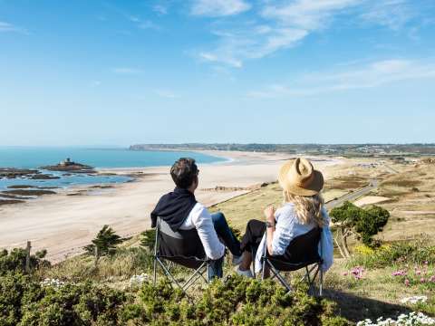 Couple bask in the sun overlooking St. Ouen's Bay