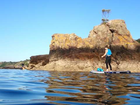 paddle boarder near rock