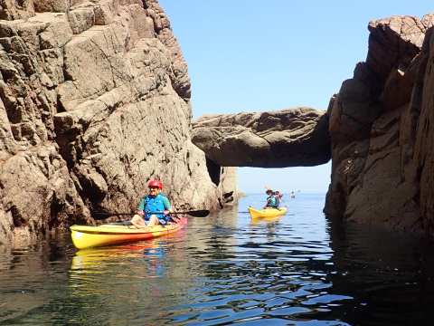 kayaks under a huge stone bridge
