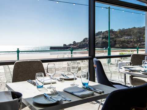 A floor-to-ceiling window with views across St Brelade's Bay