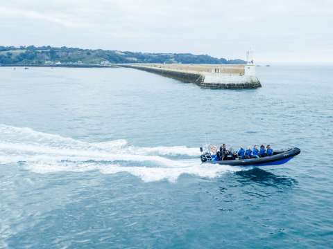 Jersey Seafaris heading out to sea with St. Catherine's Breakwater in the background