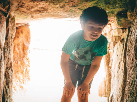 Boy enters passage grave at La Hougue Bie