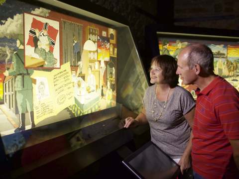 Couple look at the Occupation Tapestry panel in the gallery