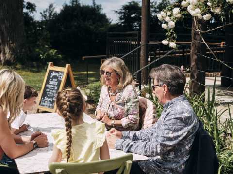 La Hougue Bie Family sit outside having coffee