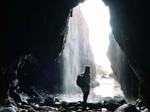 Person standing in front of the waterfall at Plu00e9mont Bay