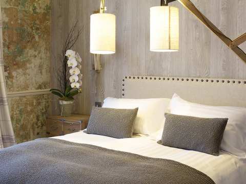 A king-size bed with decorative pillows and modern lamps