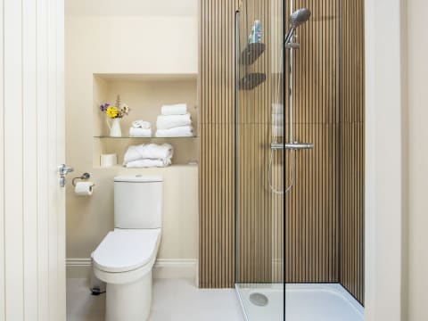 Ensuite bedroom with large shower, toilet, fluffy towels and robes