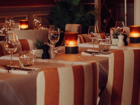 Dining chairs upholstered in a luxury orange and cream fabric