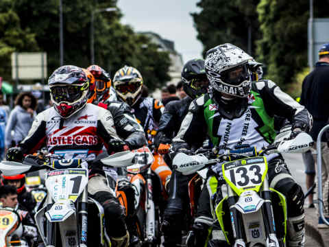 A group of modern supermoto riders preparing in the paddock