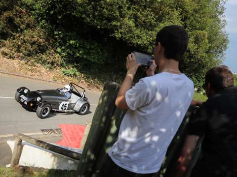 A young fan taking photos of a westfeild as it races up the hill.