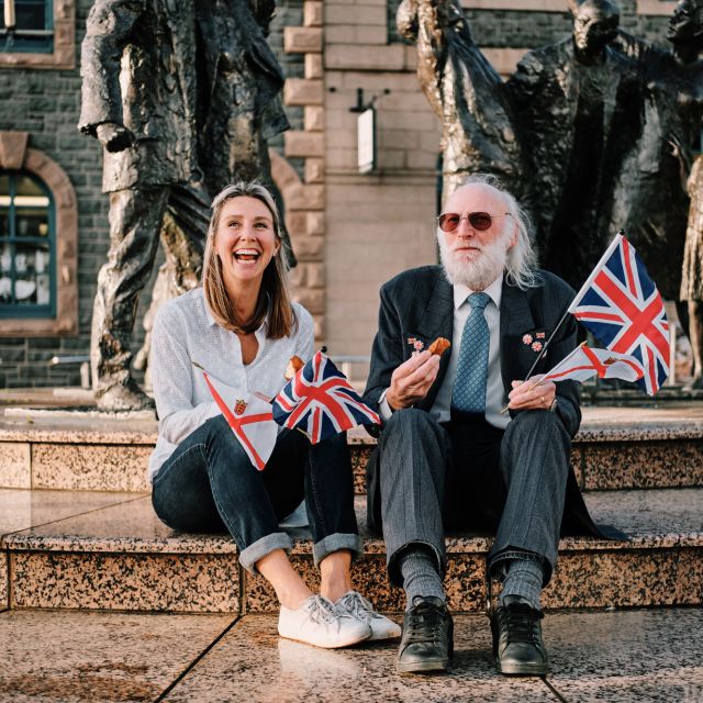 Two people sitting in front of the Liberation Statue in Liberation Square Jersey