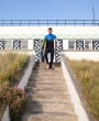Surfer makes way down private steps to beach from Barge Aground