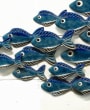 Blue ceramic fish swimming over white painted driftwood