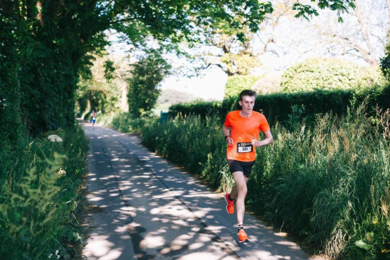 Athlete running through shaded green lane