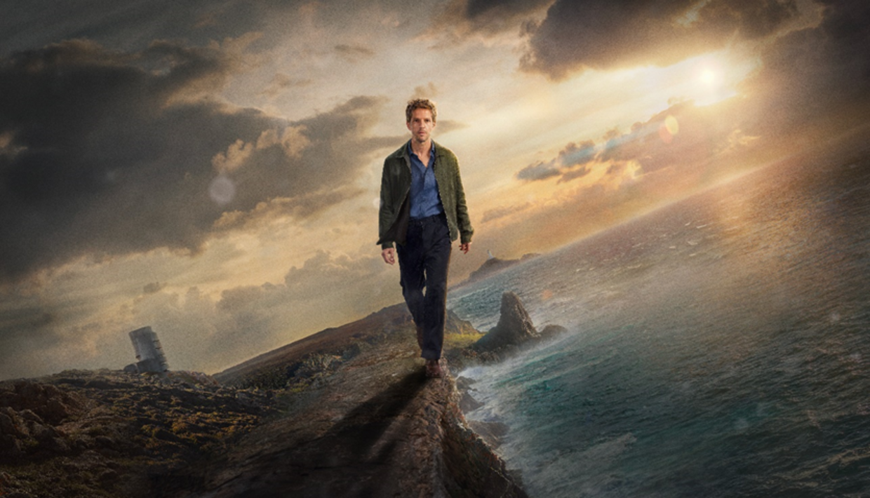 Damien Molony as Berrgerac walking along a cliff edge with the Radio Tower and Le Pinacle in the background.