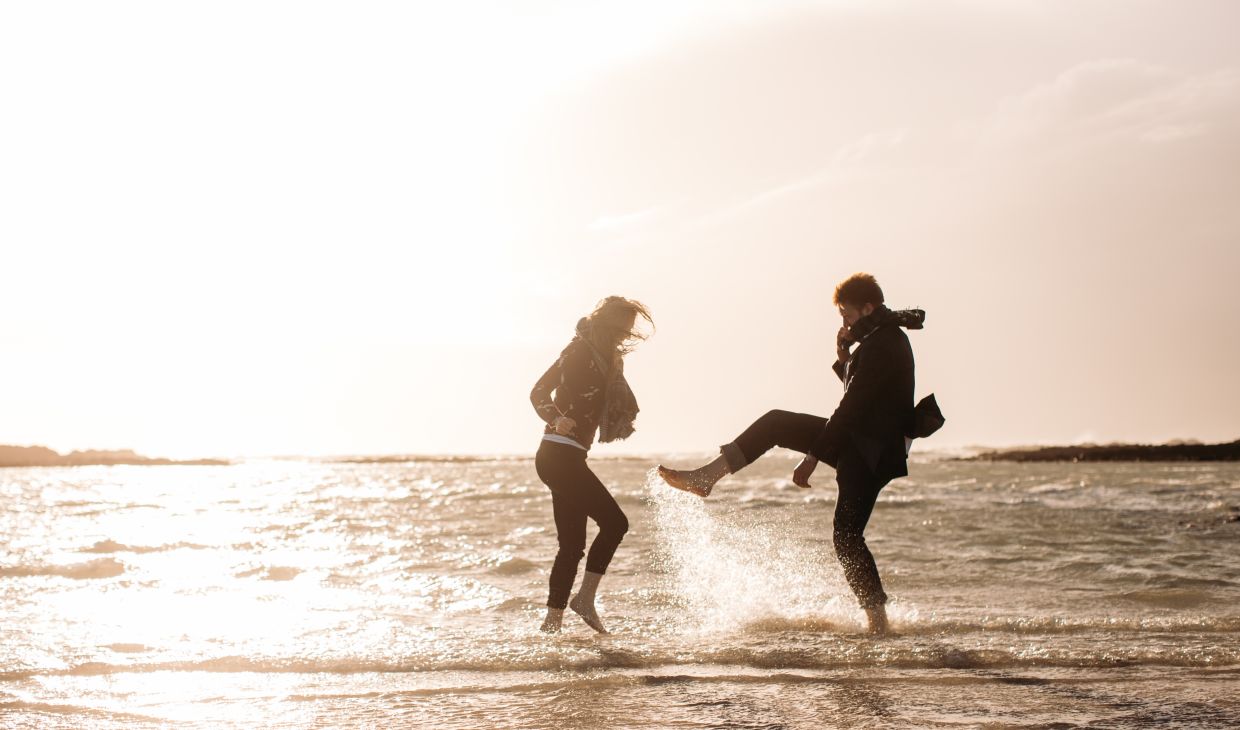 Couple walking in the water on St Ouen