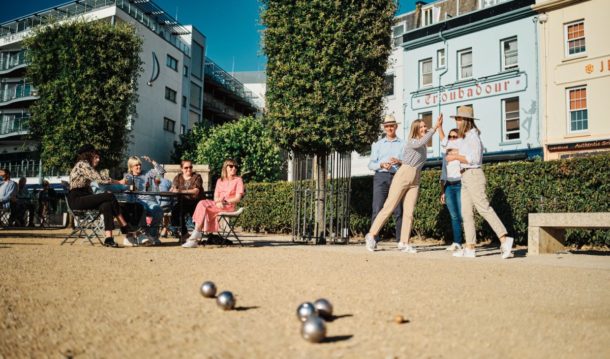 People playing petanque on gravel pitch in town center