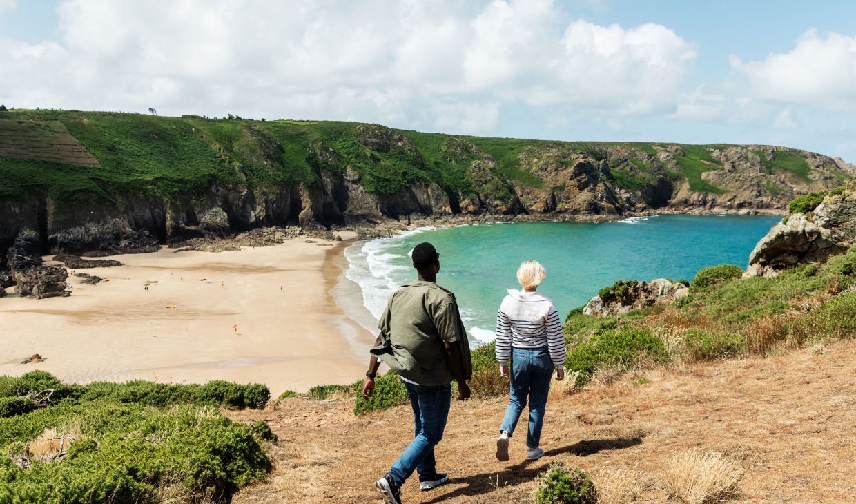 Young couple walking on the headland above Plemont Bay, Jersey