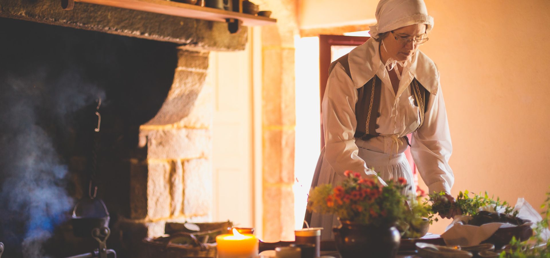 A living history actress cooking at Hamptonne Country Life Museum