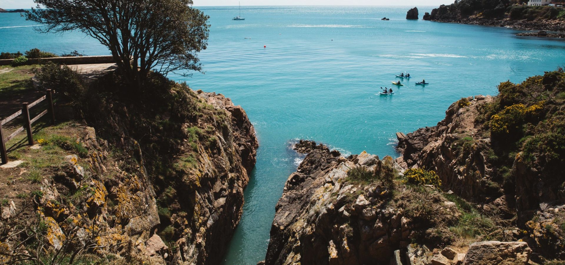 A group of kayakers paddling in the sea around from St. Brelade