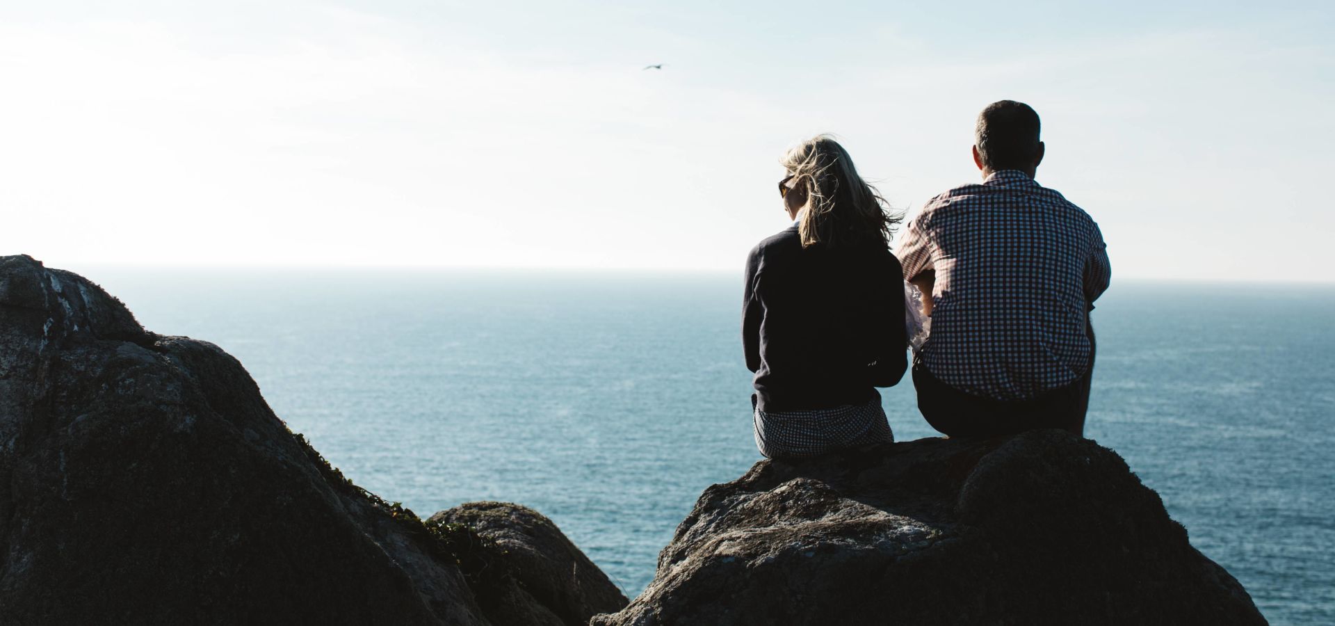 couple sitting on the top of the cliff