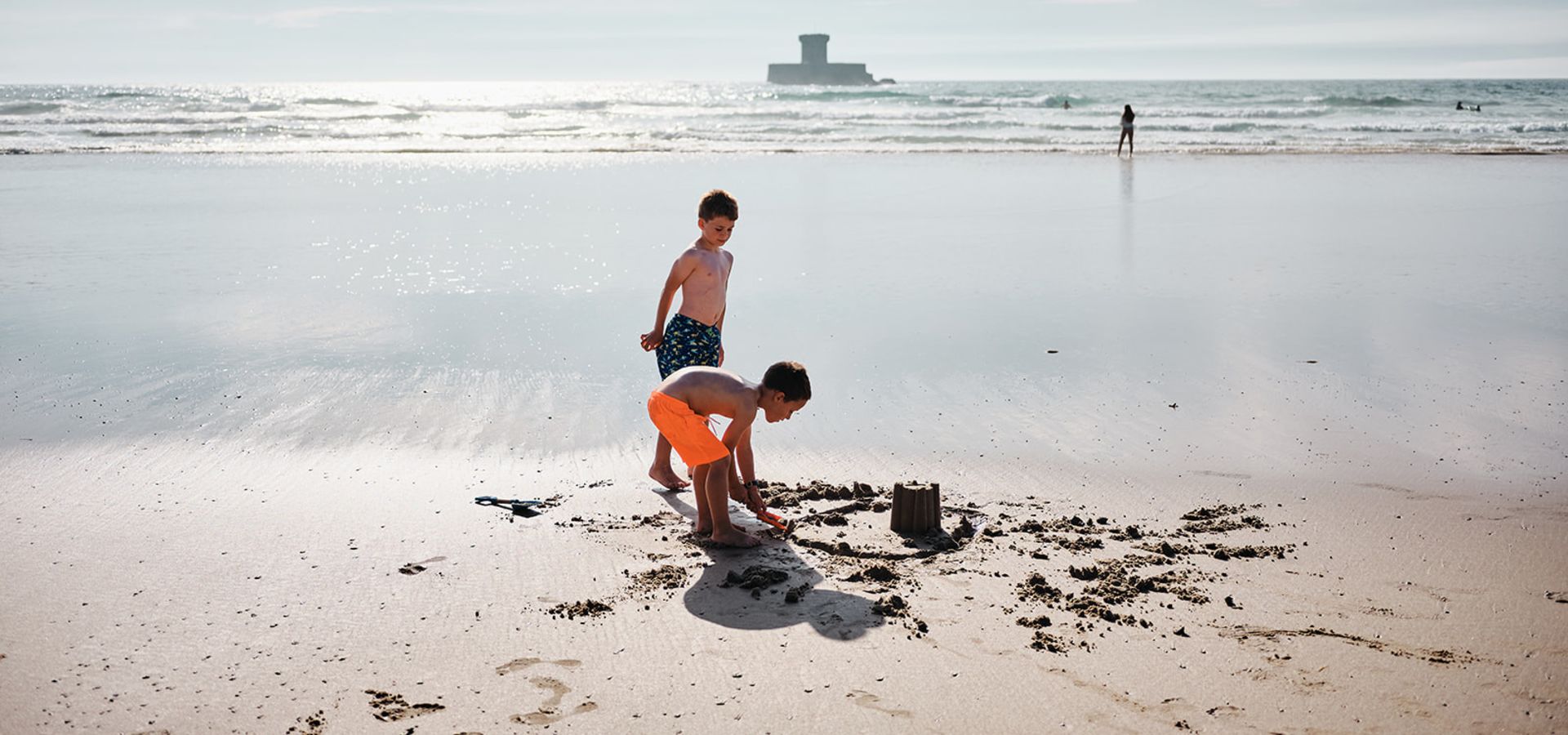 Two young boys building sandcastles on St. Ouen