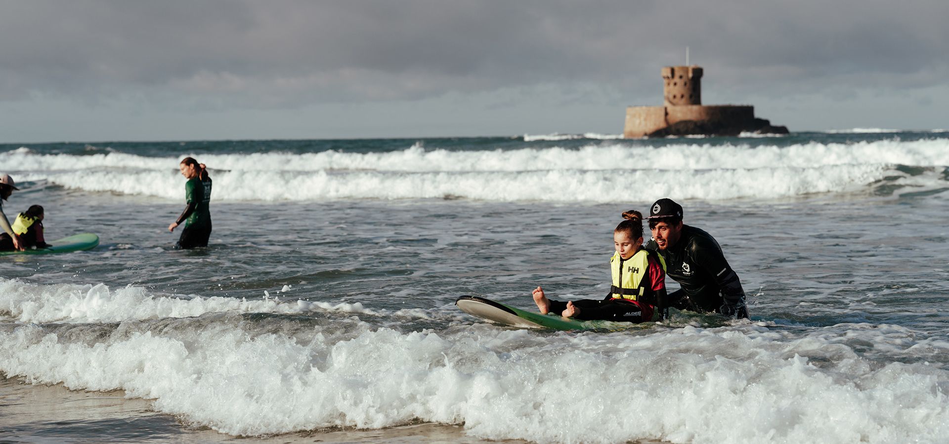 A group of children enjoying an accessible surf lesson with Healing Waves