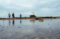 Walking at low tide near a historic tower