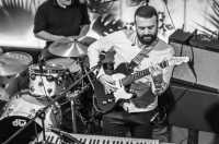 A guitarist and drummer playing in a bar in Jersey
