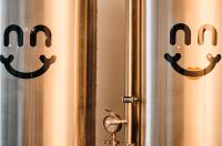 A picture of fermenting vats for beer with the Bliss Brew Co. Logo on it (the logo is a smile)