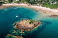 Areial shot of Janvrin's Tomb and Portelet Bay, surrounded by turquoise waters